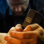 51015005-a-man-praying-holding-a-holy-bible-