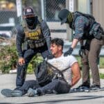 DOJ sues St. Paul over mask ban and ID requirements for federal officers Immigration agents detain a man during a protest outside an ICE processing center in Broadview, Illinois, in September 2025.