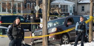 Minneapolis police officers stand by the scene where Renee Good was killed in January 2026.