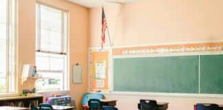 An American flag hangs in a school classroom.
